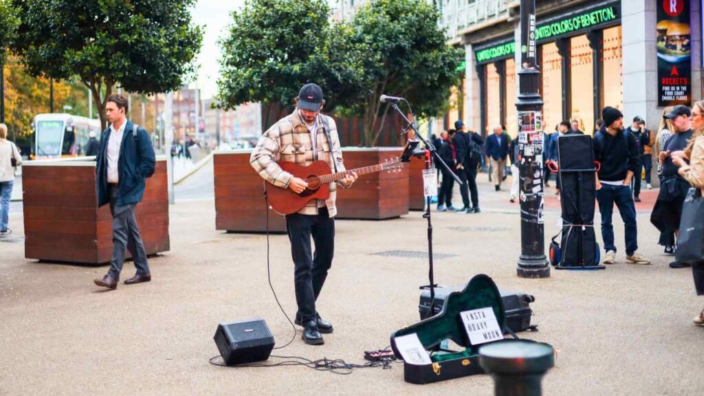 Street performer playing guitar in Dublin, Ireland. "Insta @Davy Moon" on guitar case. 2 Days in Dublin.