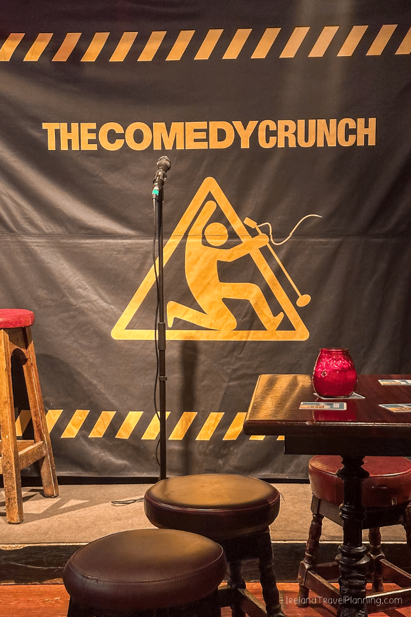 The Comedy Crunch stage in Dublin with microphone and stools, a free Dublin activity.