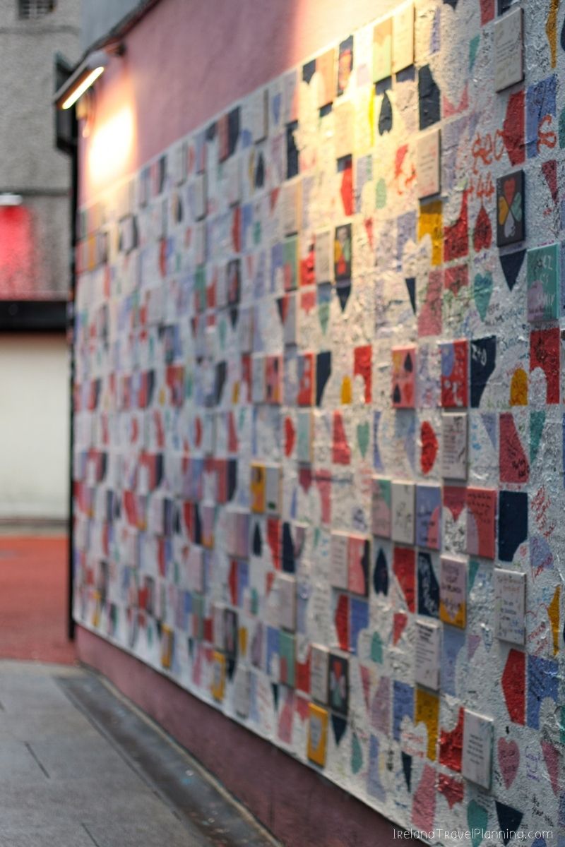 Dublin street art: Colorful tiles with messages on a pink wall, free things to do in Dublin.