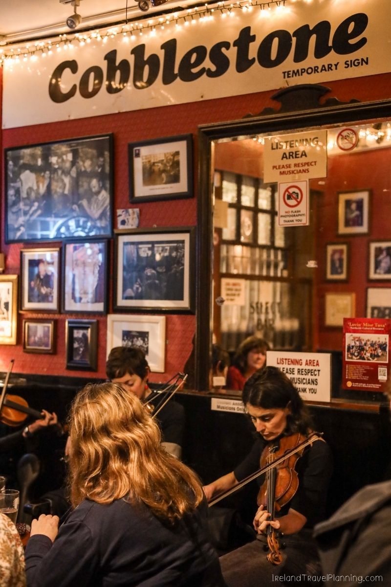 Cobblestone music venue in Dublin with musicians playing in the foreground.