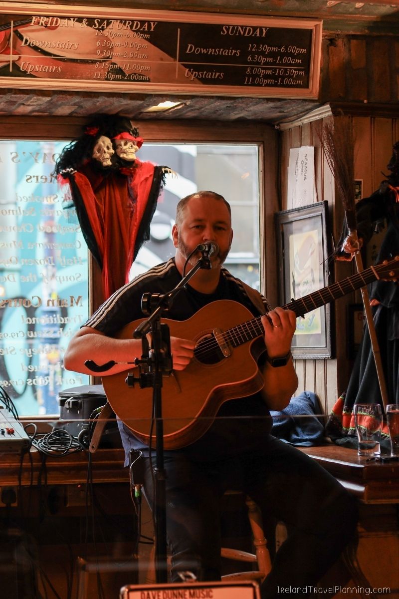 Musician playing guitar at a pub, a free Dublin experience.