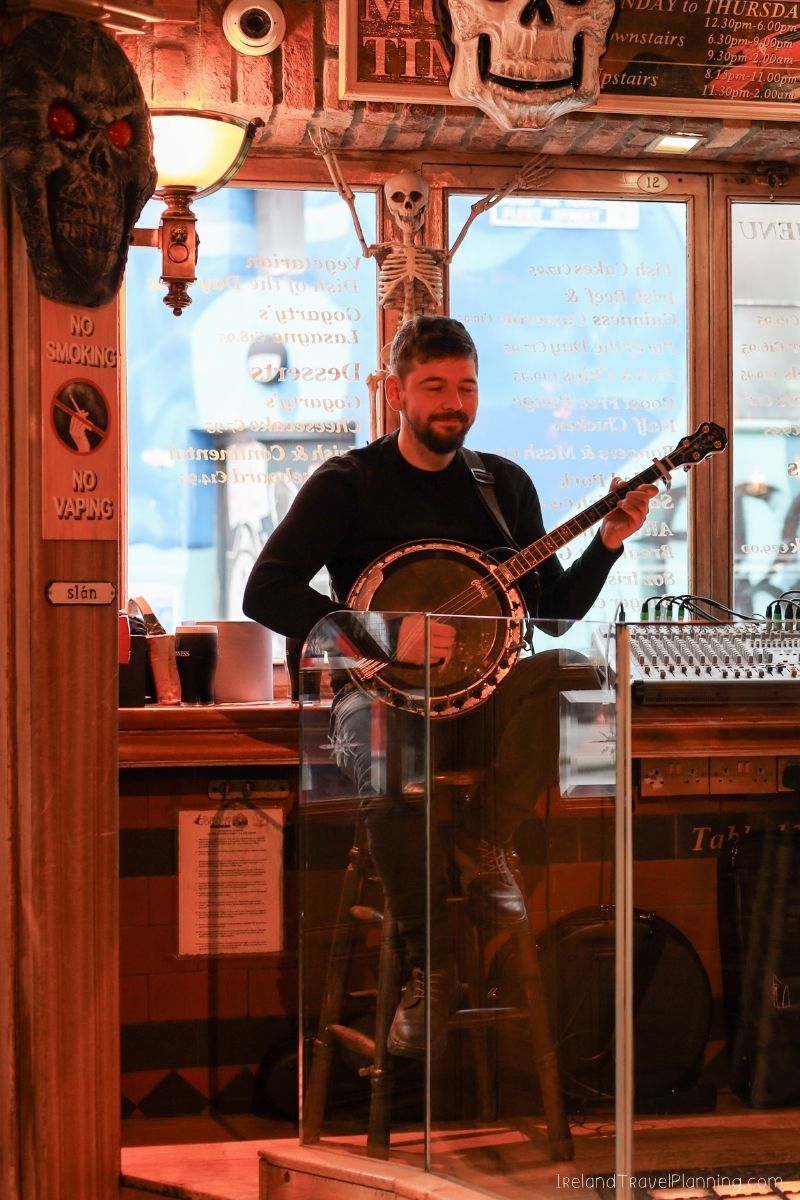 Musician playing banjo in a Dublin pub, a free activity.