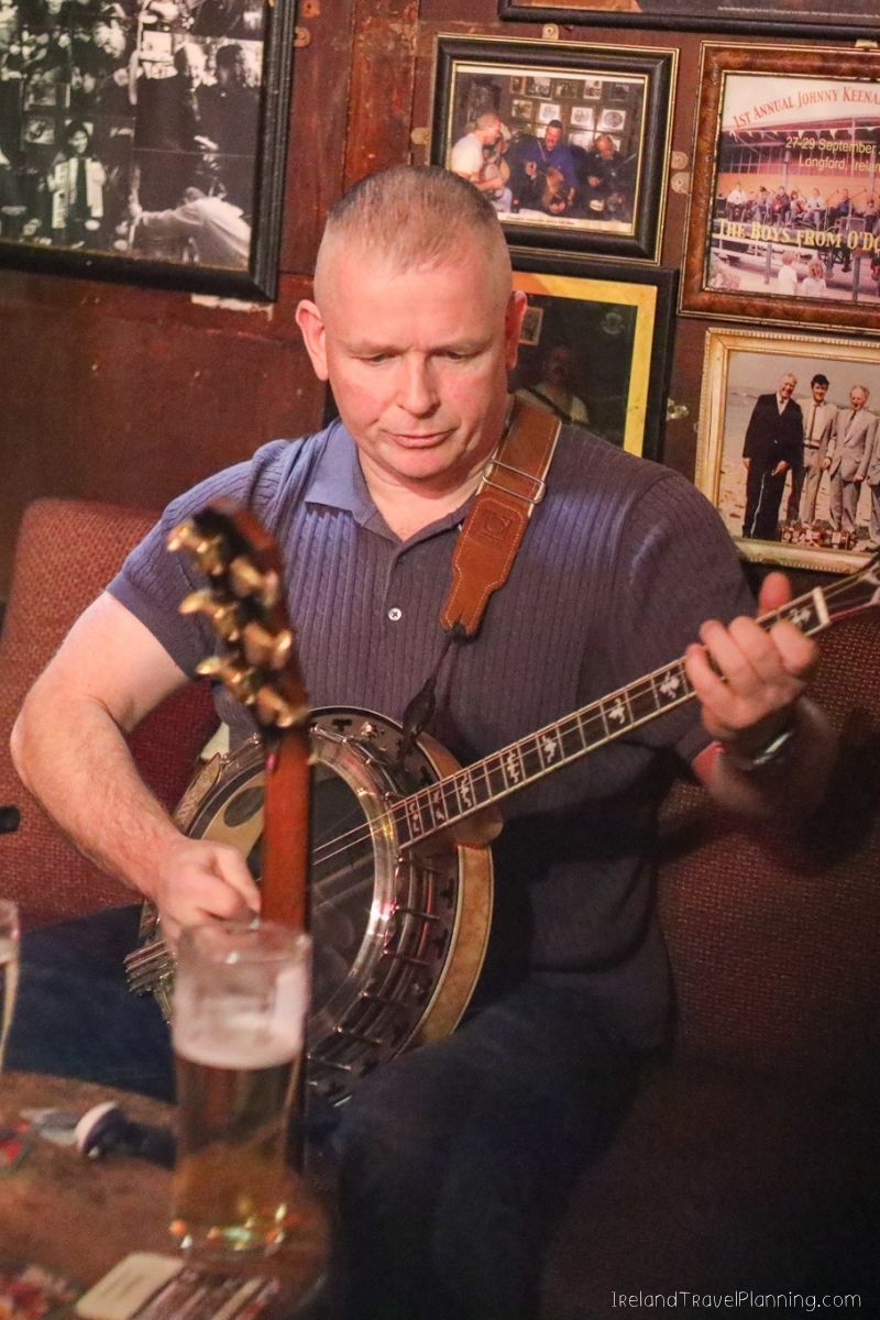 Man playing banjo in a pub, a free Dublin experience.