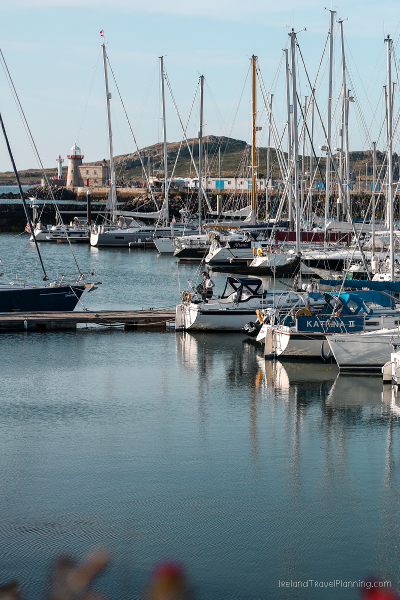 Sailboats docked in a harbor near a lighthouse, a free Dublin activity.
