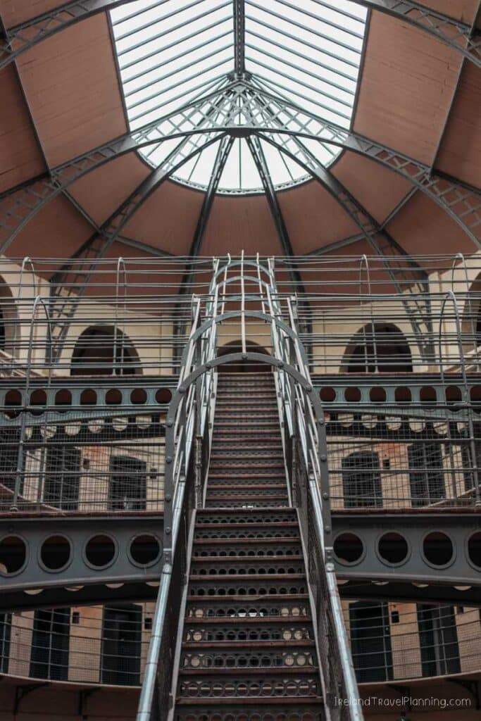 Kilmainham Gaol interior, Dublin. Iron staircase and cell blocks under a glass ceiling.