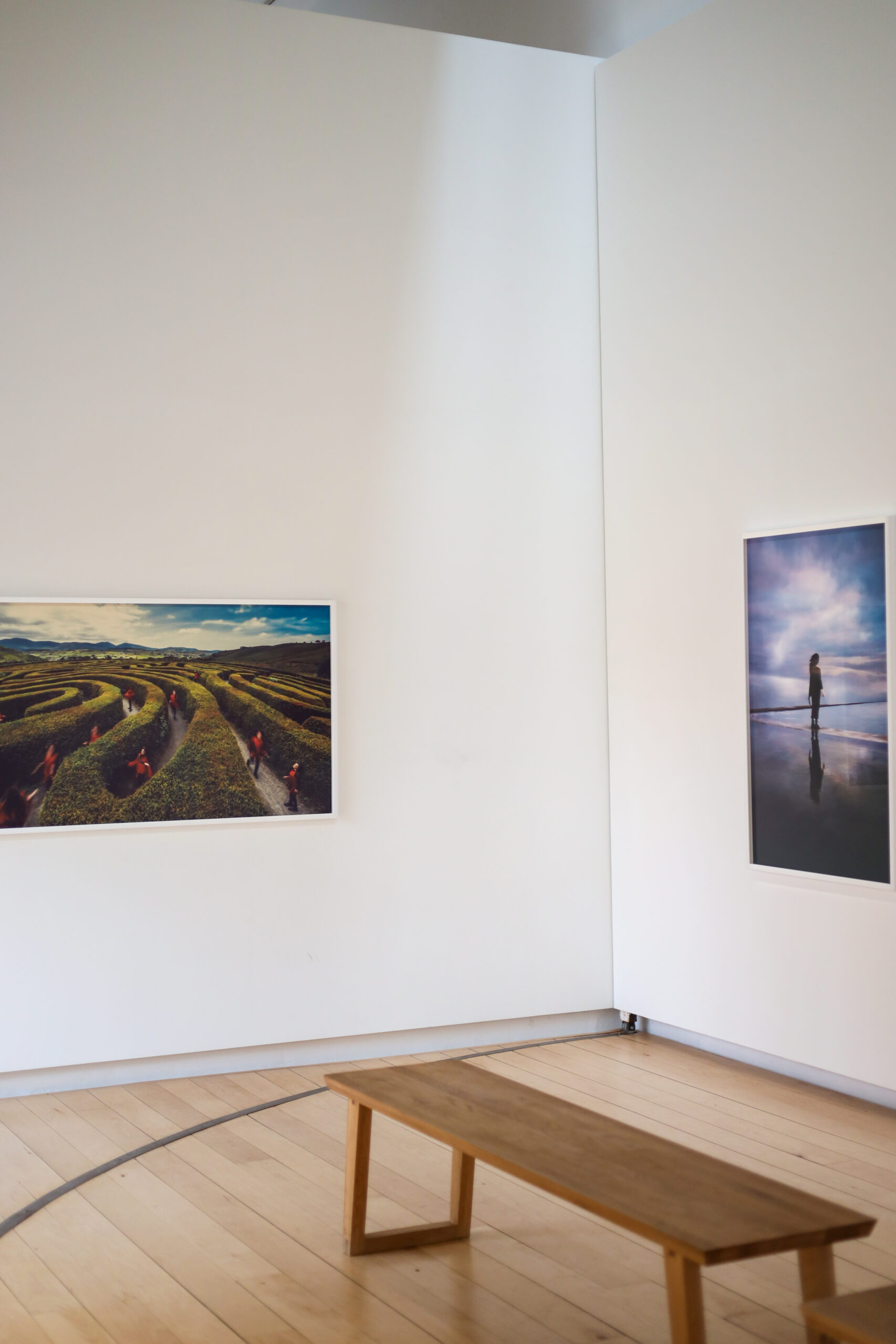 Art gallery with maze and reflection photos, wooden bench