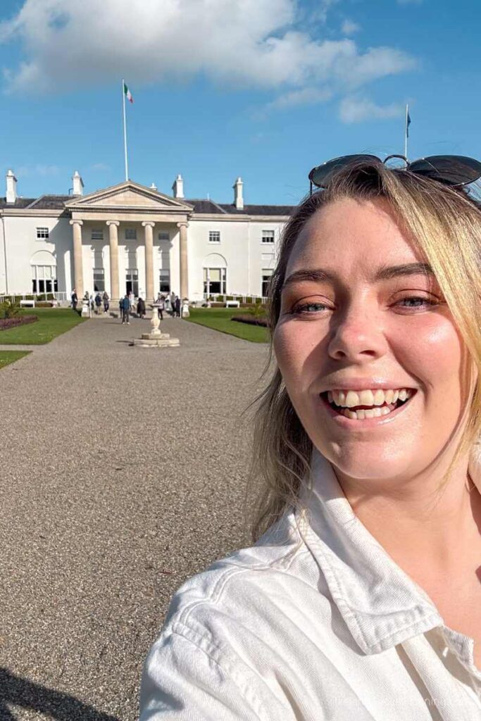 Woman smiling in front of รras an Uachtarรกin, a free thing to do in Dublin.