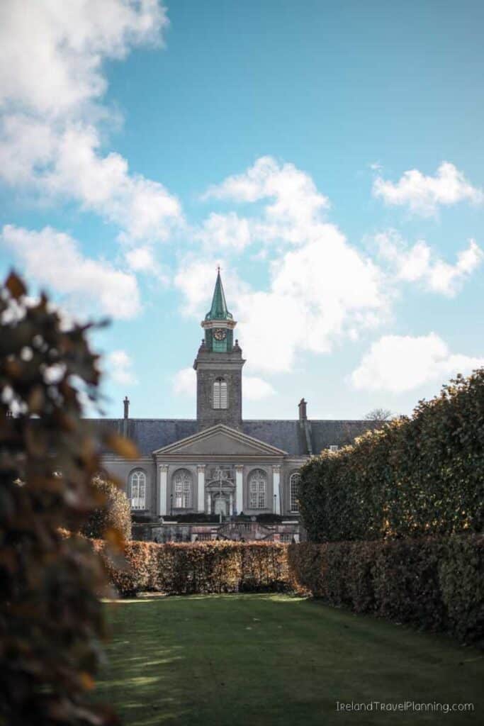 Dublin's Collins Barracks, a free thing to do, with its clock tower framed by hedges under a blue sky.