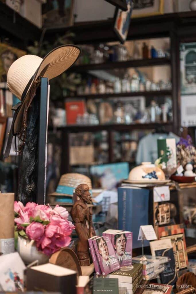 Eclectic Dublin bookstore display with hats, books, and Oscar Wilde biographies.