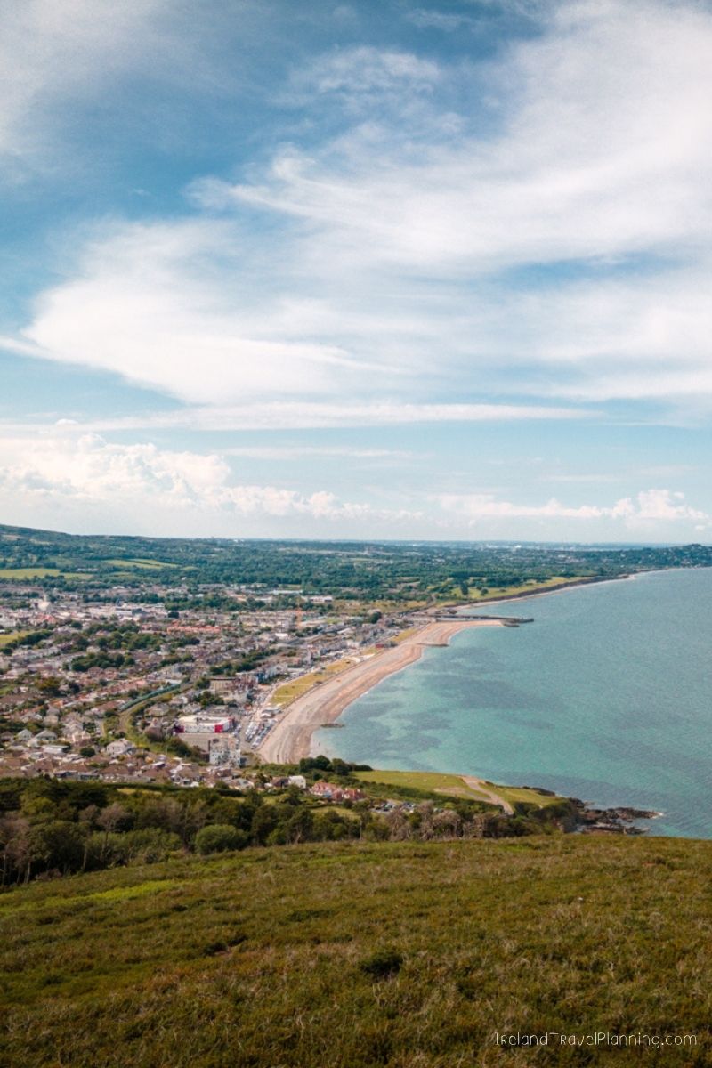 Coastal town with beach and bay, view from grassy hill, Dublin coastline
