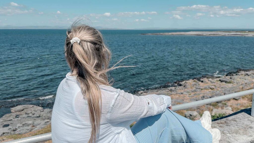 Woman overlooking the ocean on Inis Mór, Aran Islands. Things to do on Inis Mór include enjoying the scenery.