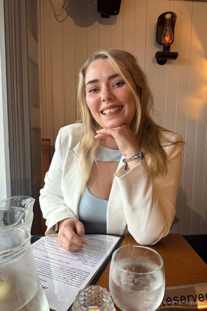Woman smiling at a restaurant on Inis Mór. Things to do on Inis Mór: enjoy the local food.