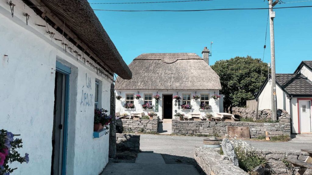 Traditional thatched cottage on Inis Mór, Aran Islands. "Teach Aran" sign visible.
