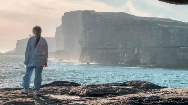 Woman views dramatic cliffs on Inis Mór.