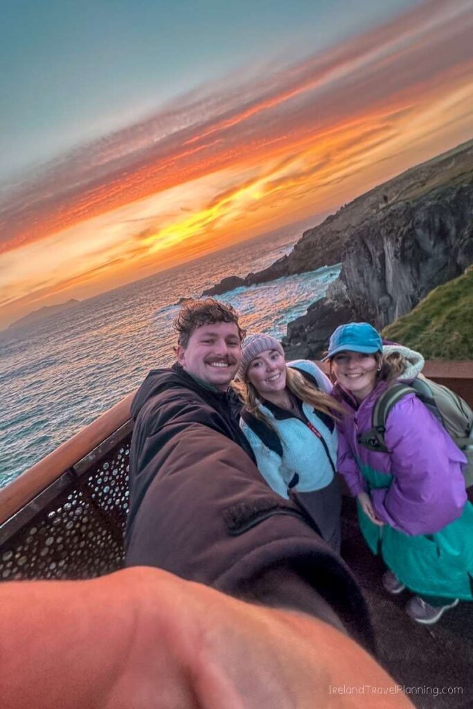 Friends at sunset on the Kerry Cliffs, a must for things to do in Kerry, Ireland.