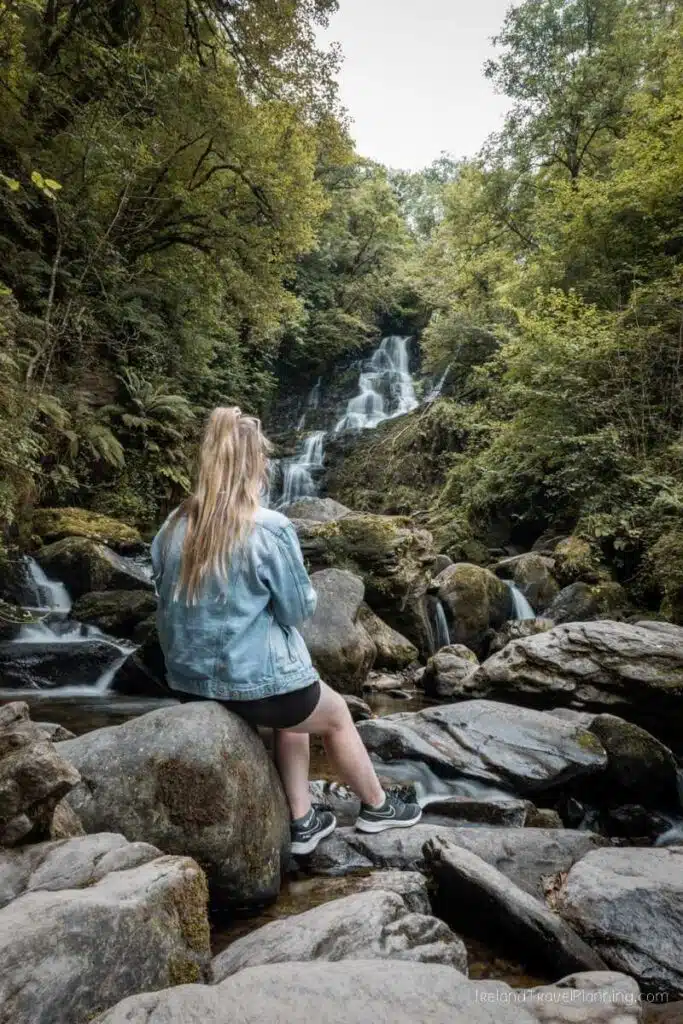 Woman at Torc Waterfall, a thing to do in Kerry.