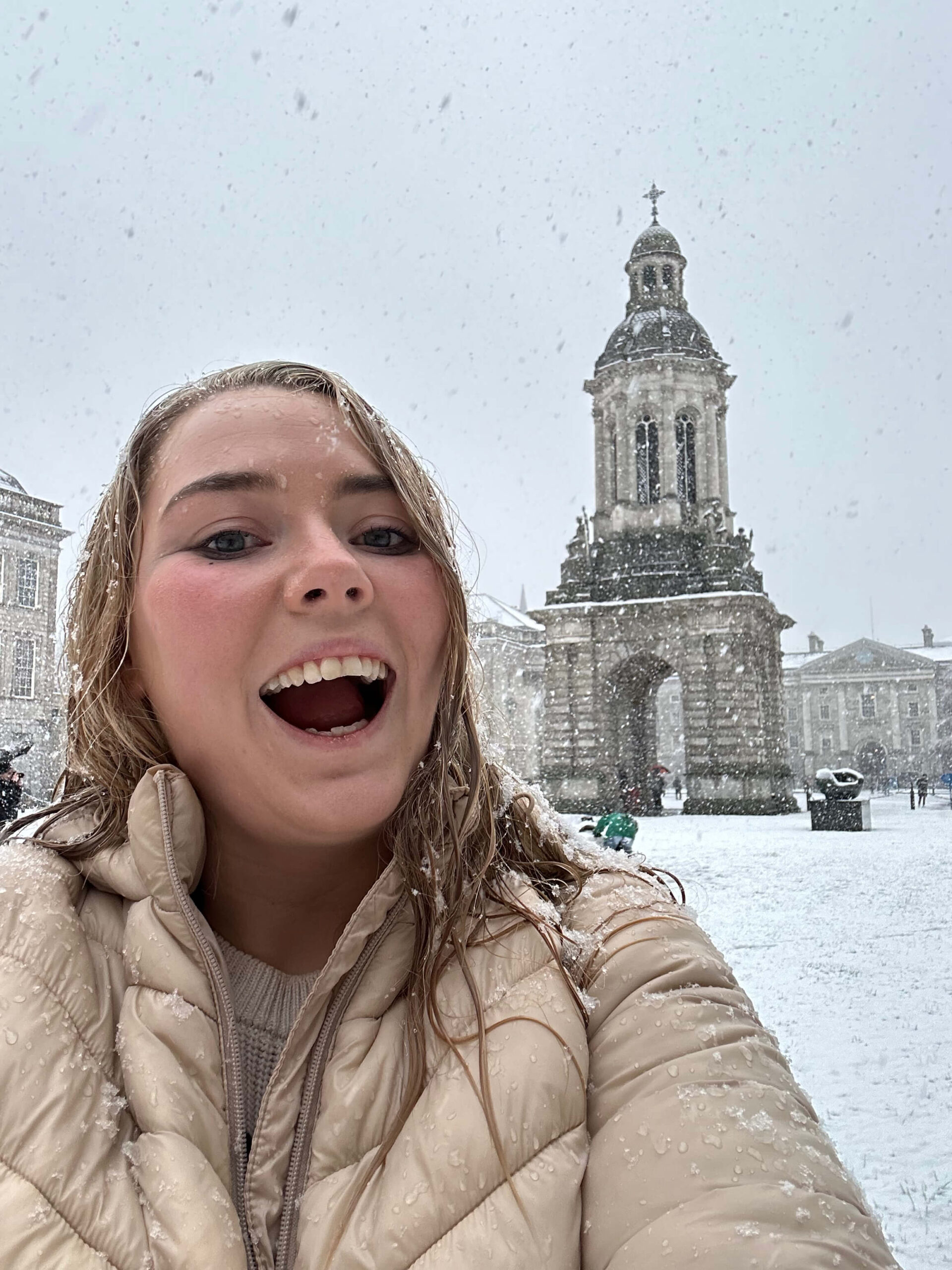 Woman in snow at Trinity College Dublin, breaking unspoken rules.
