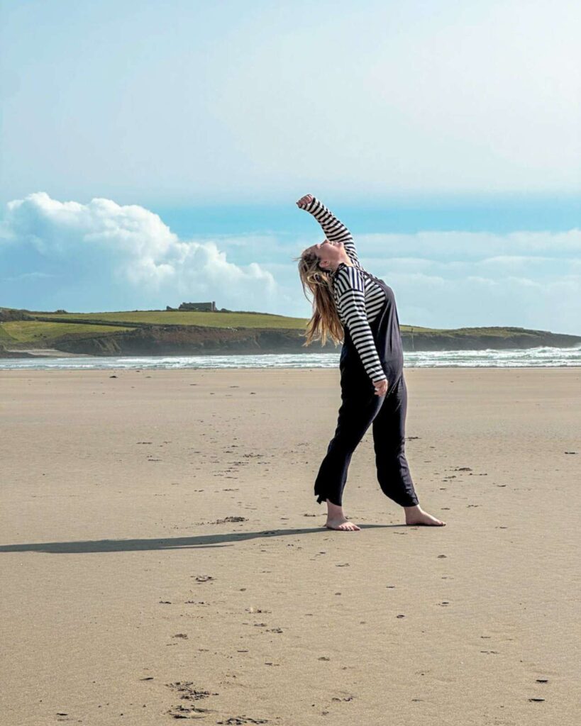 Inchydoney Beach girl standing on the sand infront of the coastal view County Cork Ireland