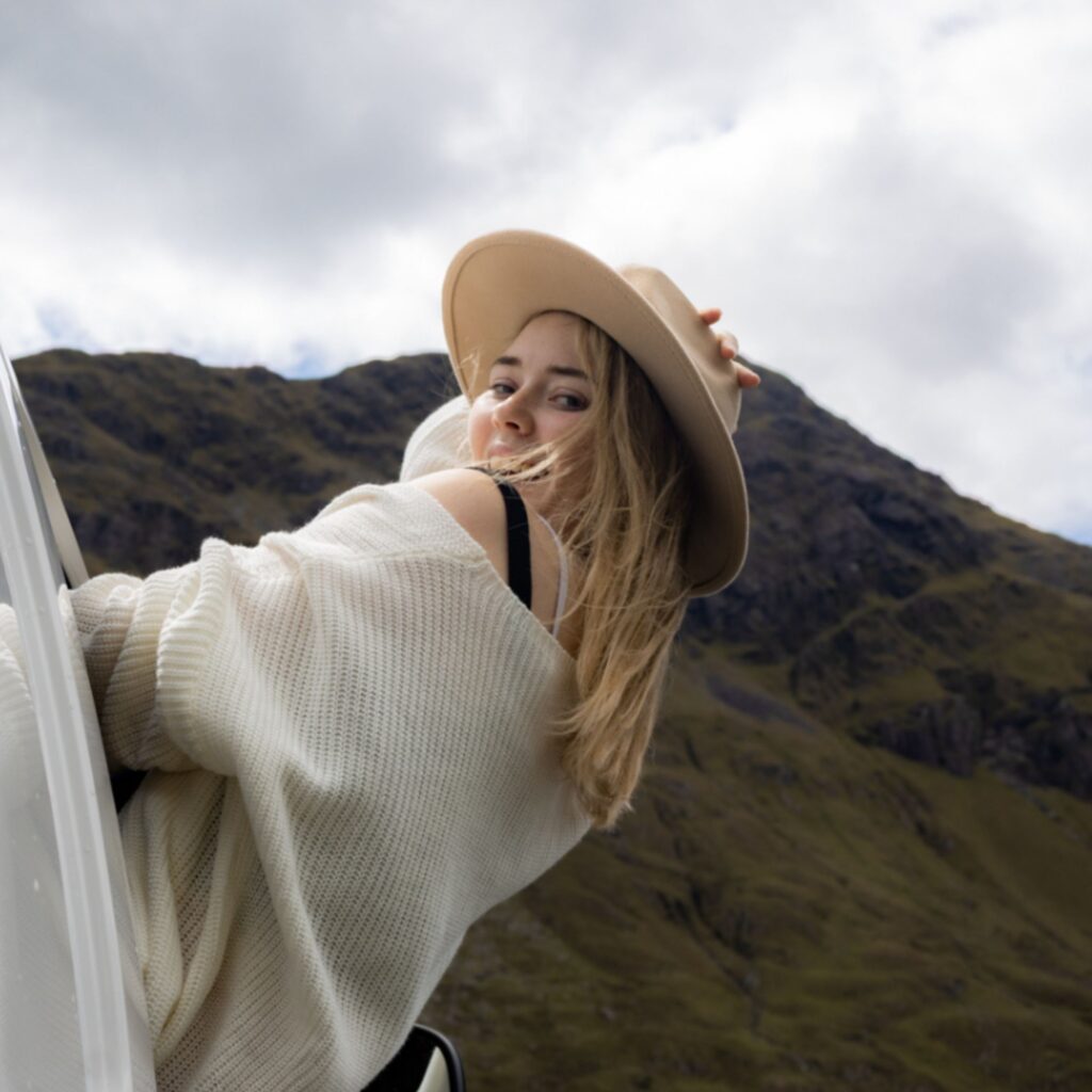 Woman looking back from a car window during a drive in Ireland