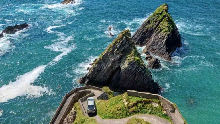 Car driving in Ireland on a coastal road near Dunquin Pier in Ireland.