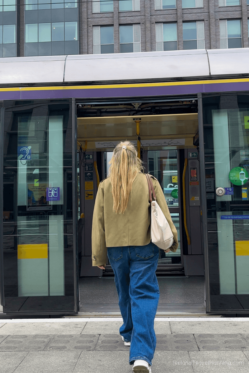 Woman boarding a tram in Dublin, part of public transport in Dublin.