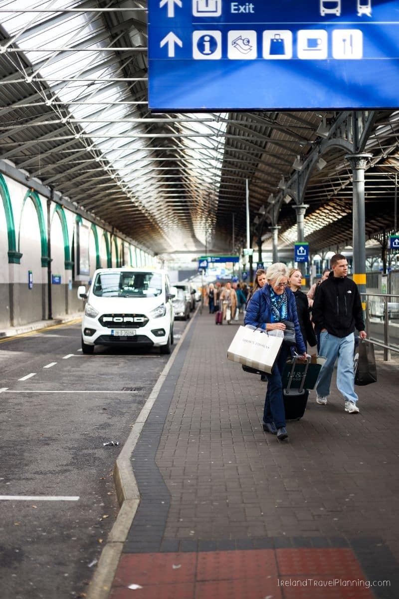 Tourists with luggage at Dublin Airport arrivals, hinting at public transport in Dublin.