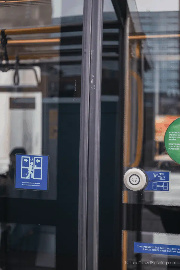 Dublin bus door with accessibility and ticket validation signs.