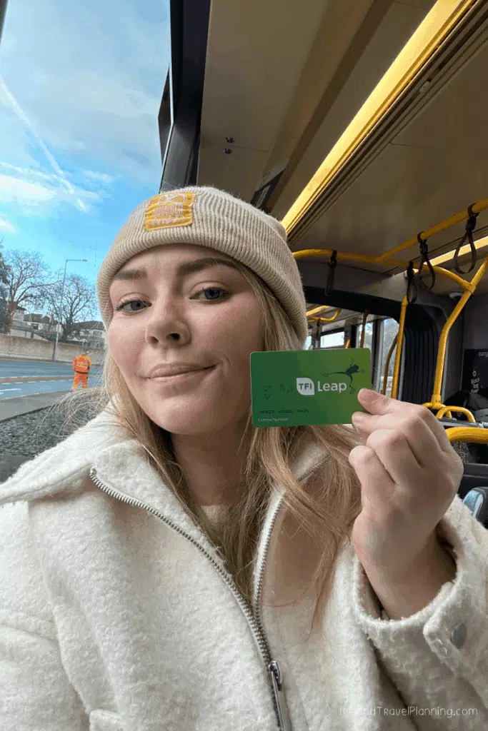 Woman on Dublin bus holding TFI Leap card for public transport