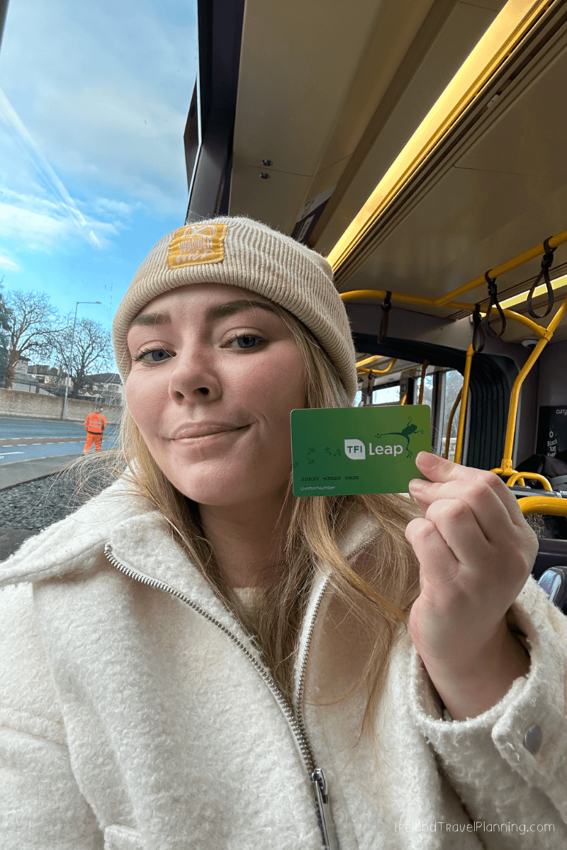 Woman on Dublin bus holding TFI Leap card for public transport