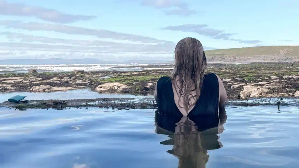 Woman in a tidal pool, enjoying Ireland's hidden gems.