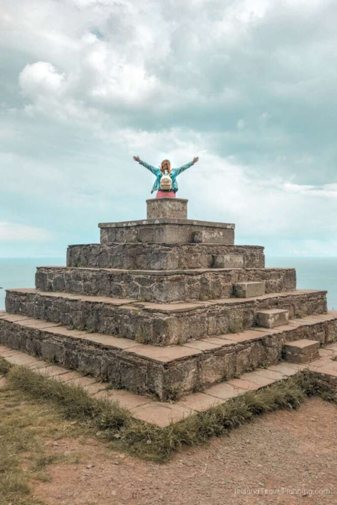 Woman atop Howth's Baily Green pyramid, a Dublin hidden gem.