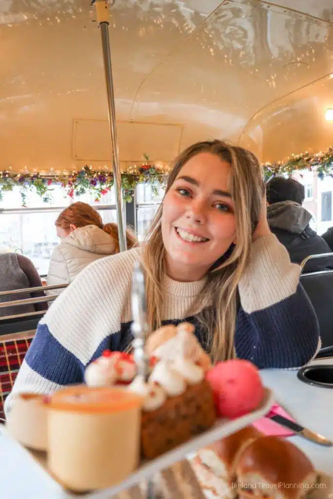 Woman enjoys afternoon tea on a vintage Dublin bus tour, one of Dublin's hidden gems.