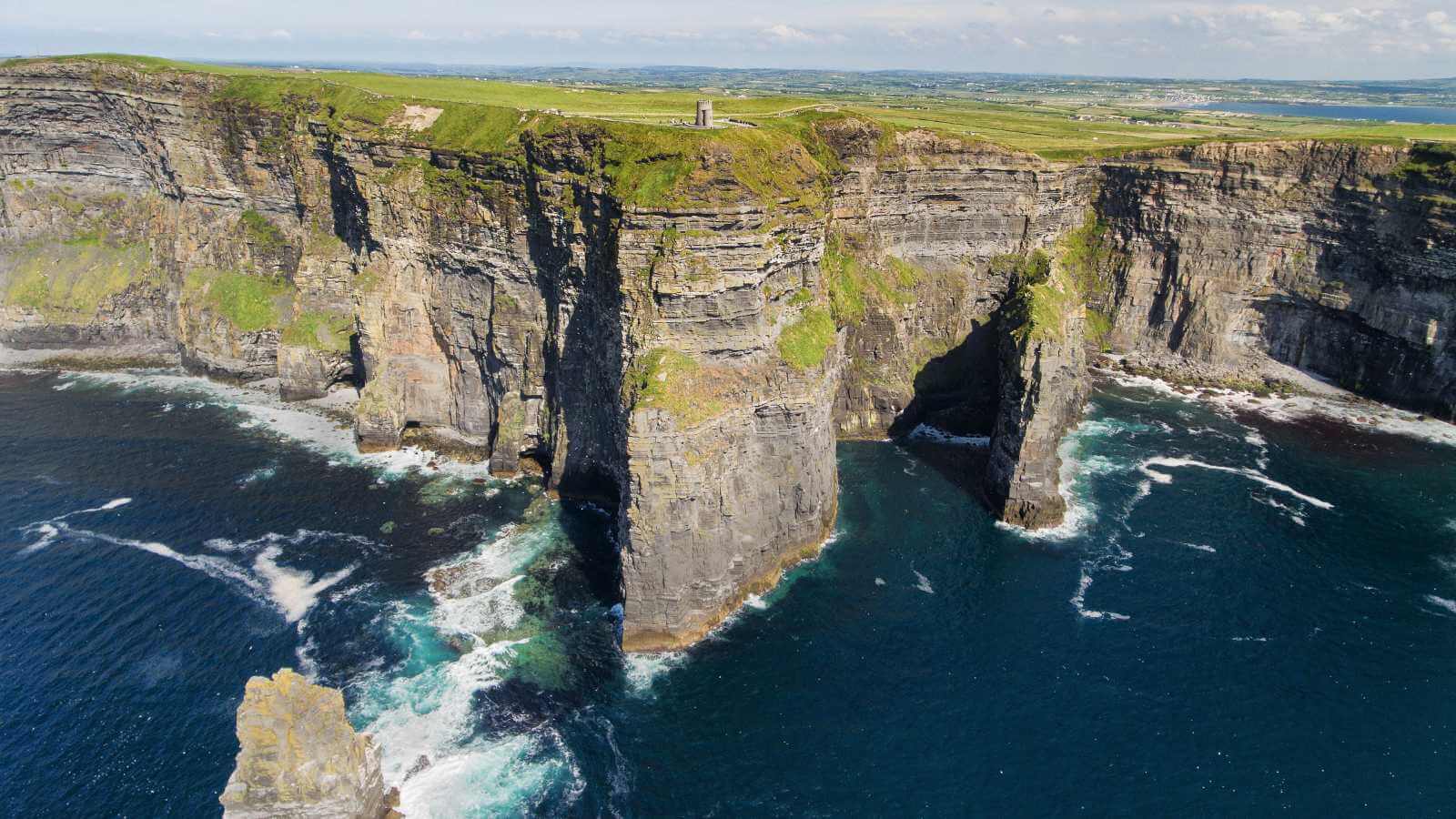 Cliffs of Moher, Ireland. Hikers on top of the dramatic sea cliffs.
