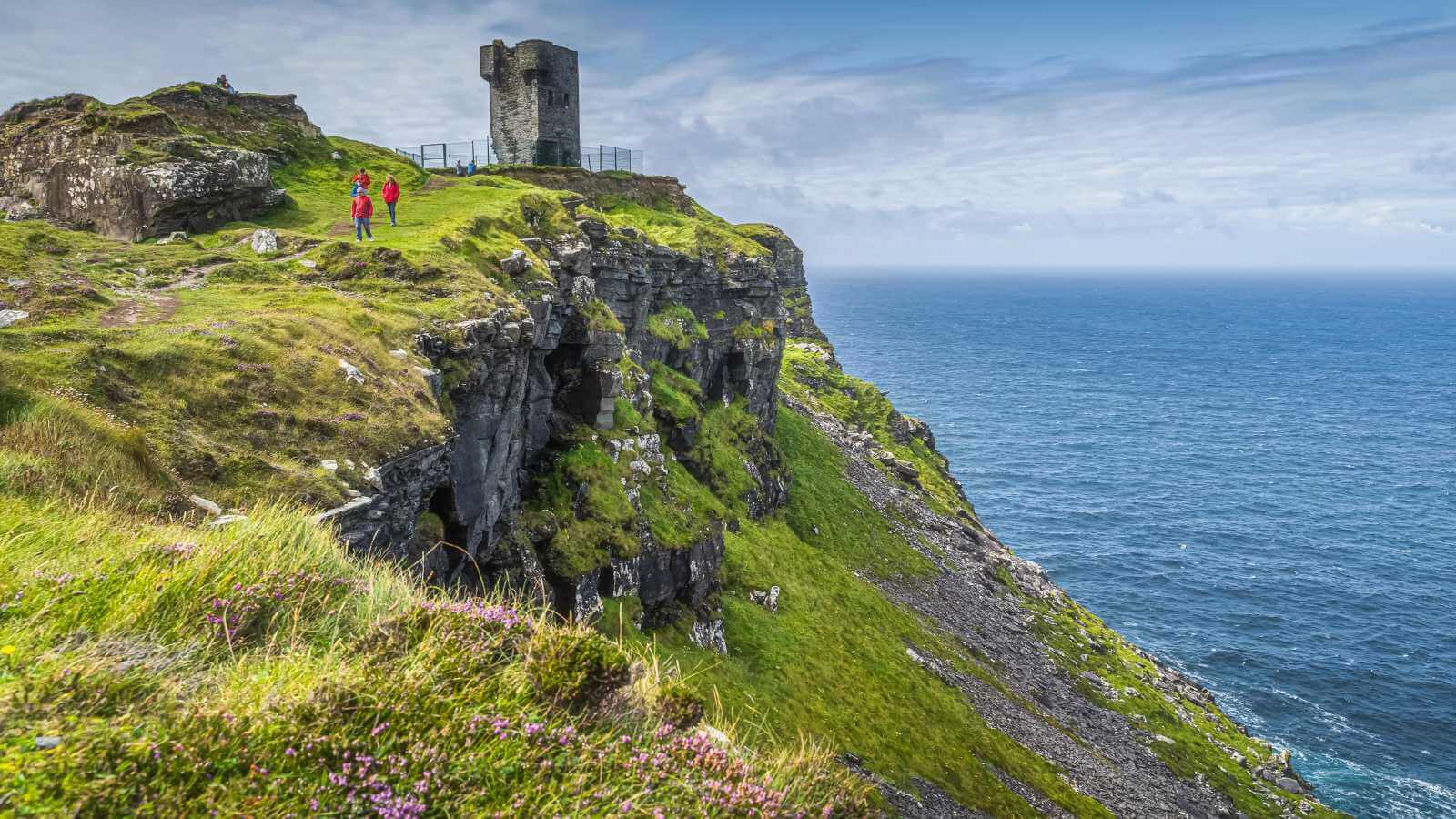 Cliffs of Moher with O'Brien's Tower, Ireland. Green cliffs meet the blue ocean.