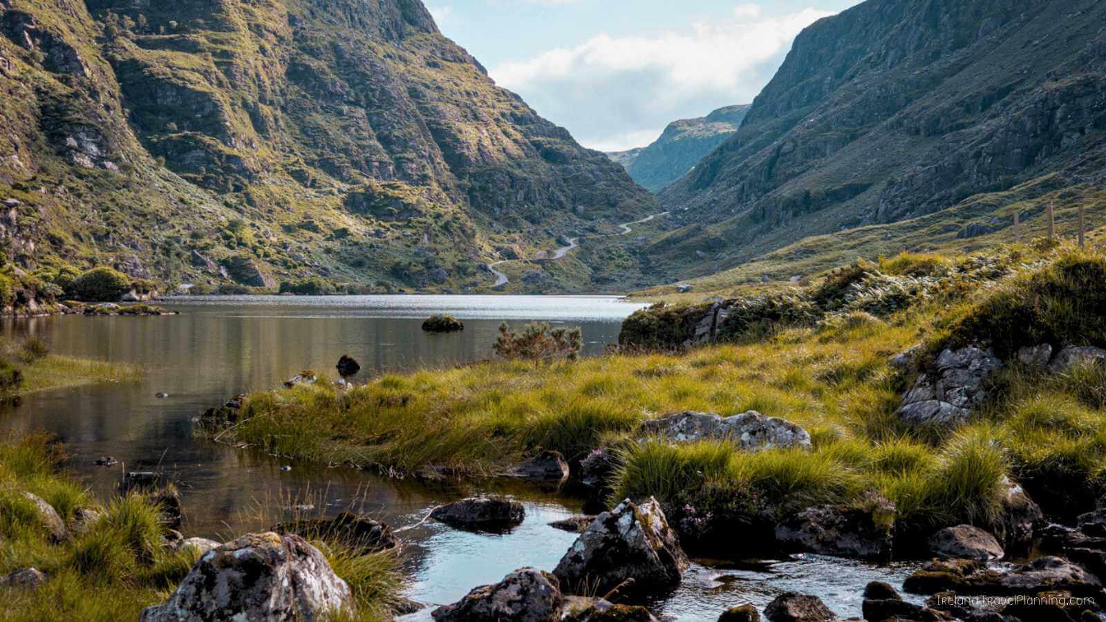 Scenic view of Gap of Dunloe, Ireland, with a lake, mountains, and winding road.