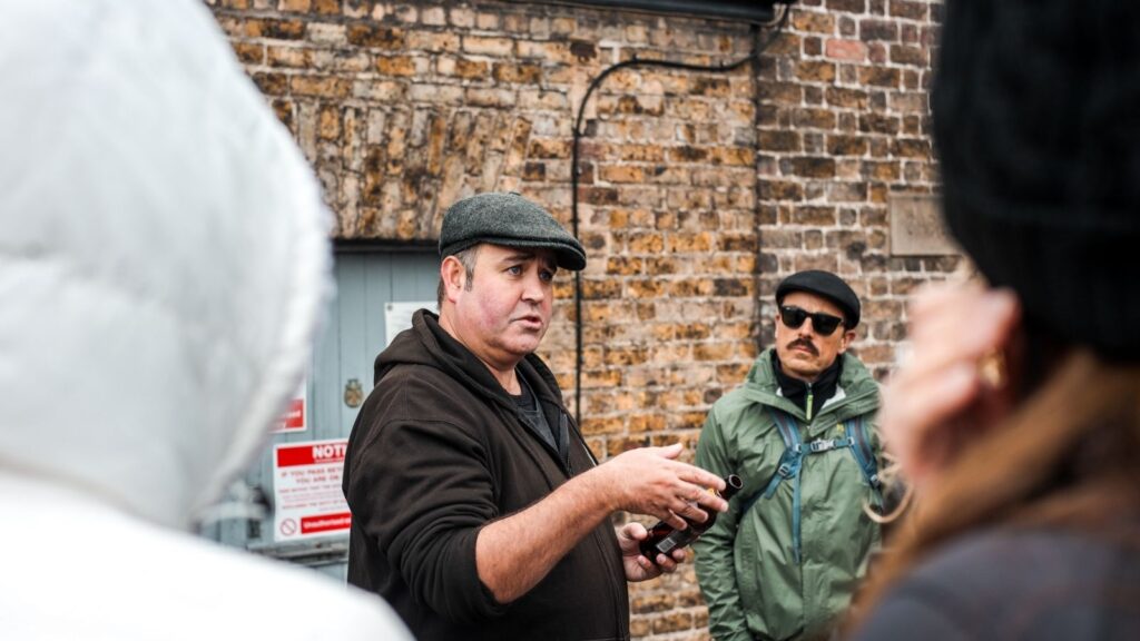 Dublin tour guide speaking to a group in front of a brick building.