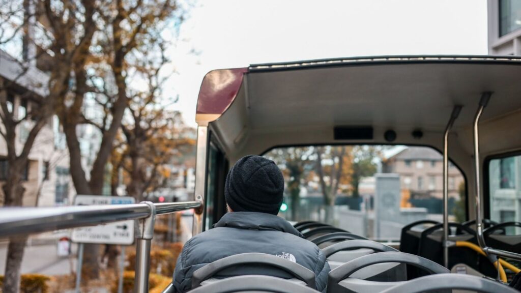 Person on a Dublin tour bus, top deck view. Dublin Pass blog content.