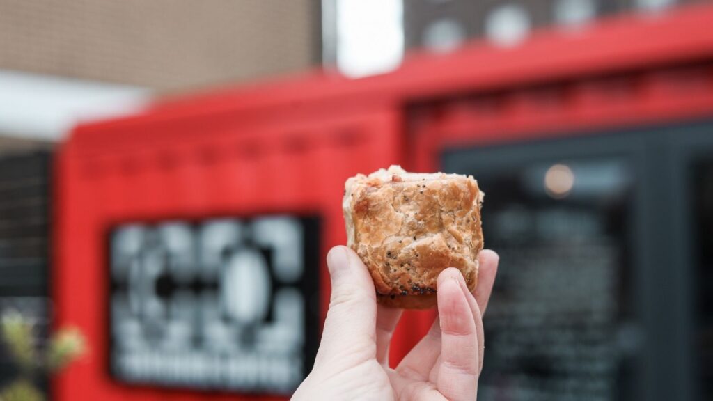 Hand holding a sausage roll in Dublin, Ireland.