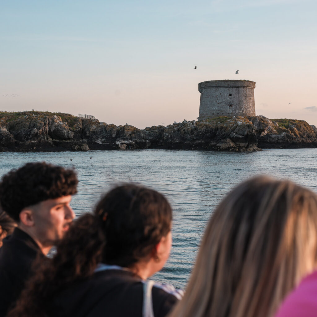 Martello Tower on Dalkey Island, a Dublin attraction, with people in the foreground.