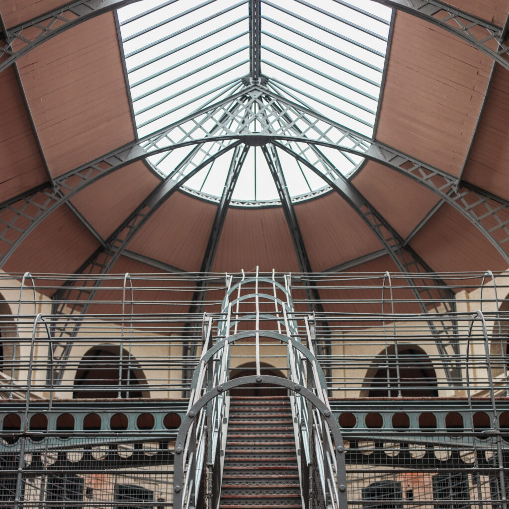 Interior view of Kilmainham Gaol's iron and glass roof structure, a Dublin attraction.