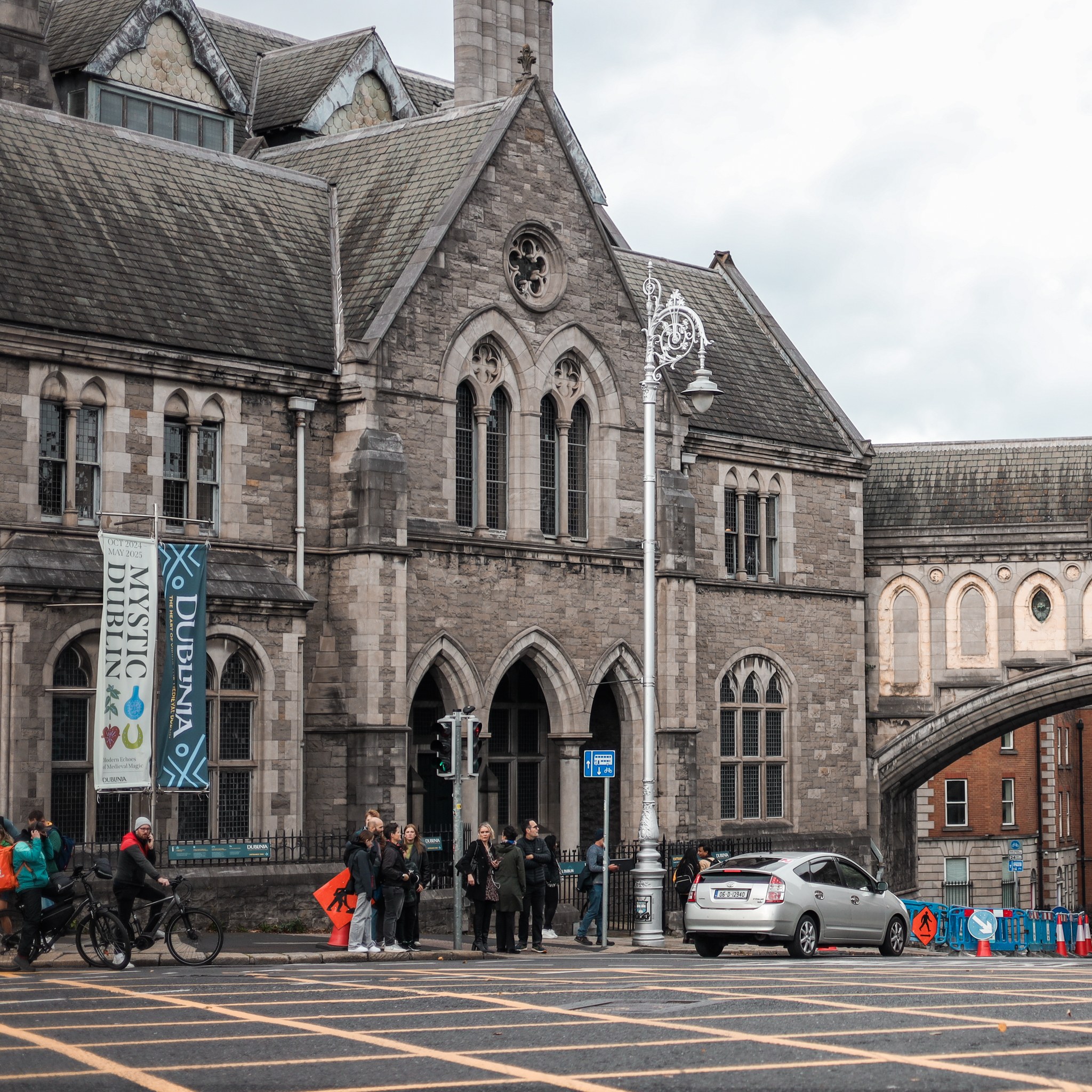Dublinia museum in Dublin, Ireland, with people crossing the street. "Mystic Dublin" banner visible.