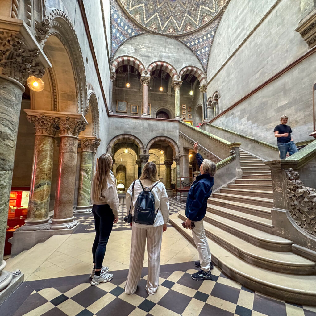 Dublin attraction: Ornate interior of a building with people admiring the architecture and staircase.