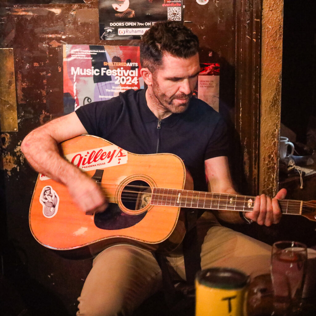 Man plays guitar at Dublin's Sheltered Arts Music Festival 2024.