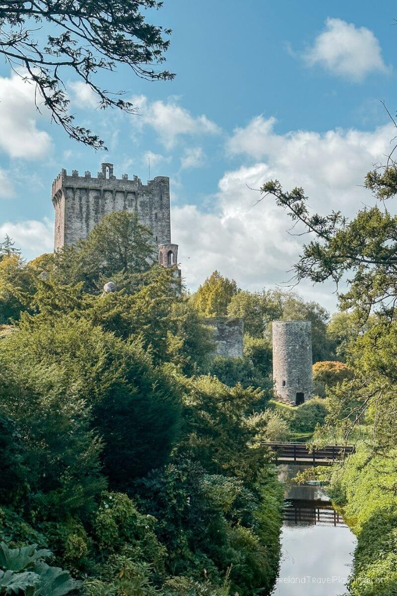 Old tower ruins Blarney Castle surrounded by trees and a small river