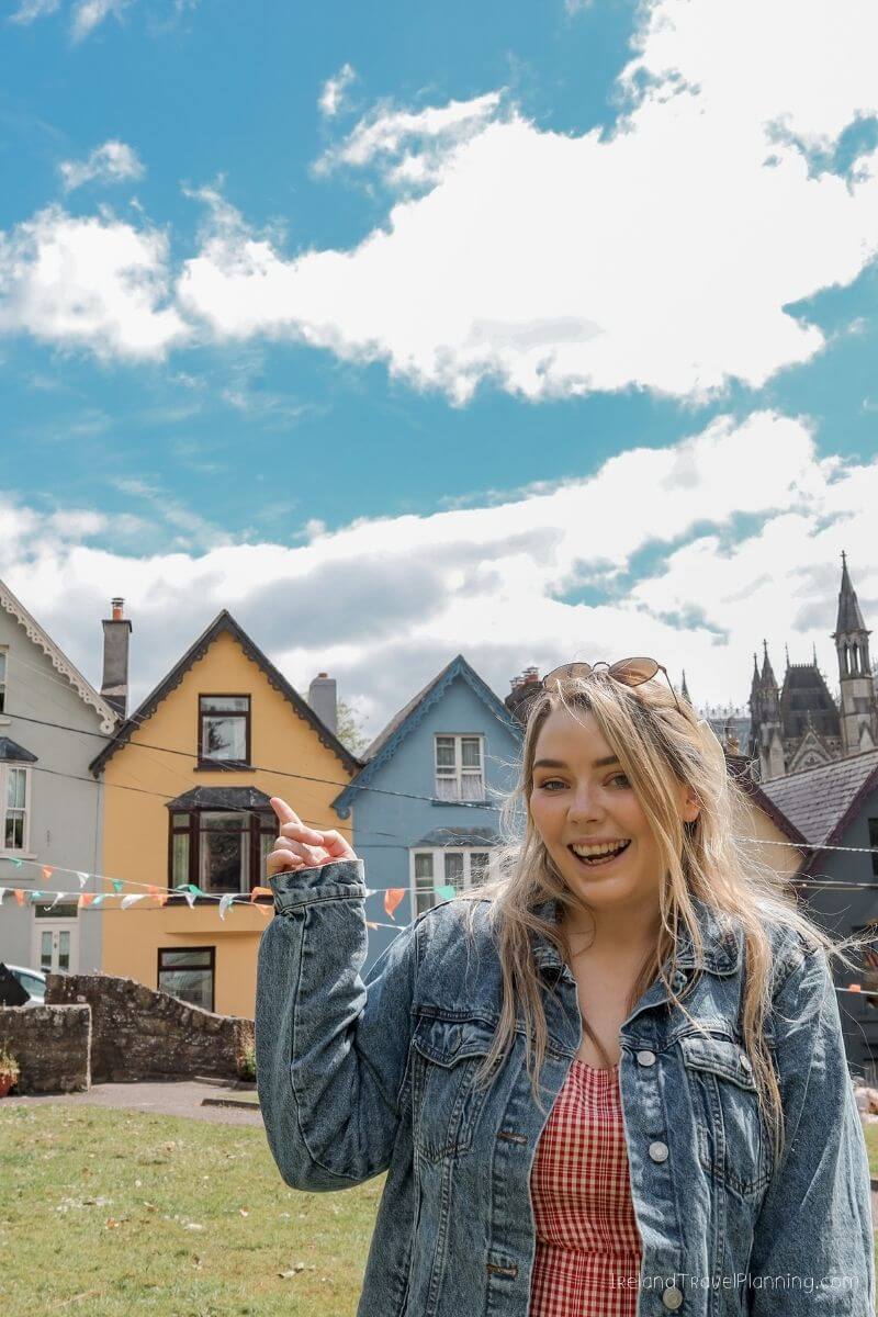 Woman pointing at colorful houses in a charming Irish town