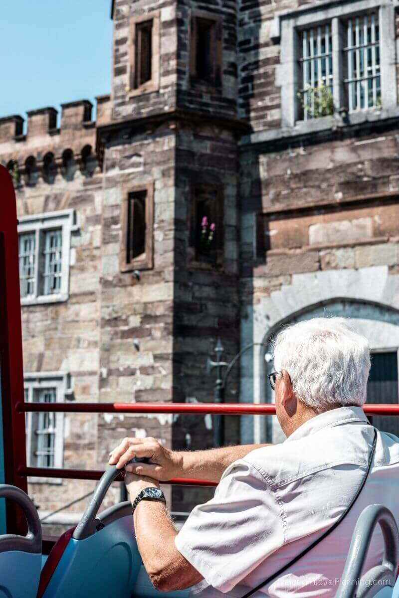Man on a tour bus in Cork City looking at a historic building