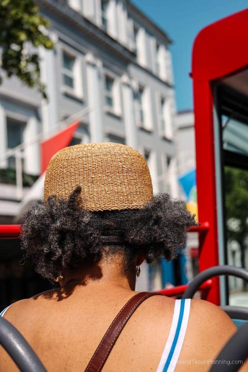 Woman in straw hat on red bus in Cork City