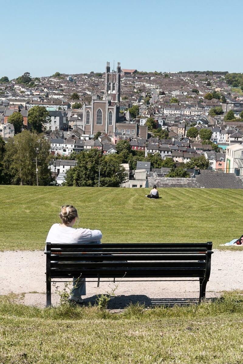 Woman sitting on a park bench overlooking Cork City