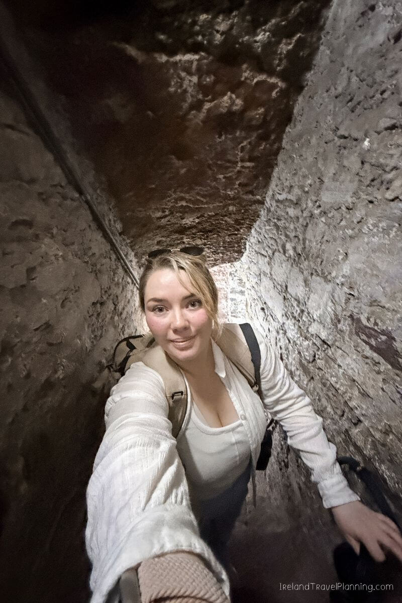 Blonde woman in white top descending narrow stairs in Cork City