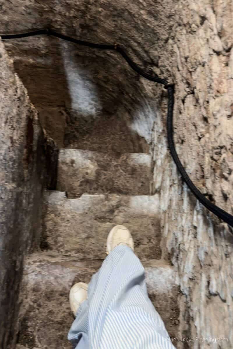 Stone steps leading down in Cork City, person wearing white shoes